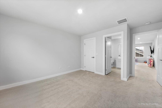 unfurnished bedroom featuring ensuite bathroom, light colored carpet, baseboards, visible vents, and recessed lighting