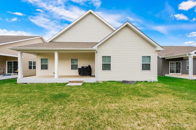 rear view of house featuring a yard and a patio