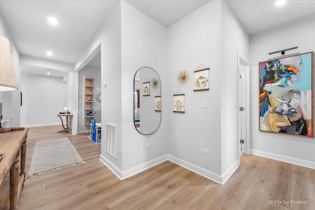 hallway featuring recessed lighting, light wood-type flooring, visible vents, and baseboards