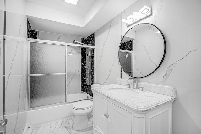 full bath featuring combined bath / shower with glass door, vanity, marble finish floor, and toilet