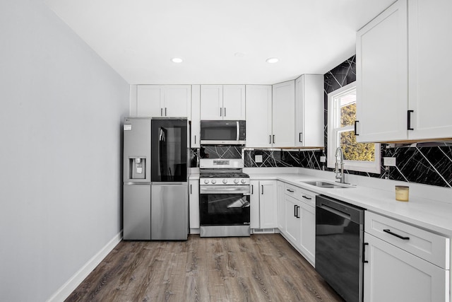 kitchen featuring a sink, dark wood-style floors, white cabinets, and stainless steel appliances