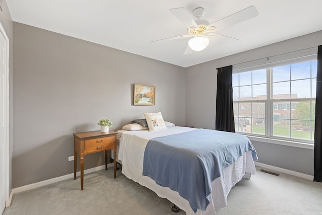 bedroom featuring baseboards, a ceiling fan, light colored carpet, and visible vents
