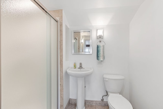 bathroom with a sink, a stall shower, and toilet