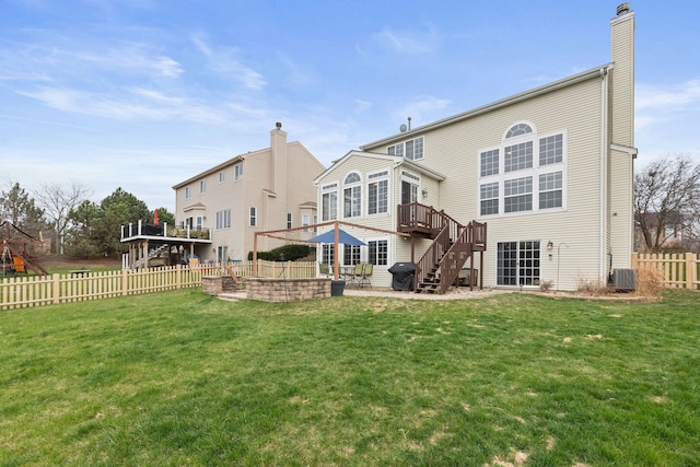 back of house featuring a chimney, central AC unit, a wooden deck, a fenced backyard, and a patio