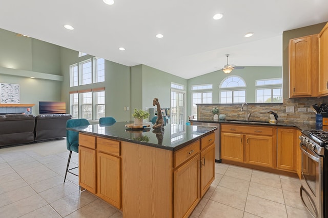 kitchen with a ceiling fan, a sink, appliances with stainless steel finishes, and a healthy amount of sunlight