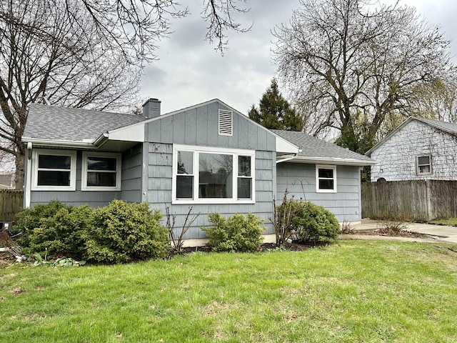 1407 Calhoun St, Peru, IL 61354 - rear view of house with fence, a lawn, a shingled roof, and a chimney