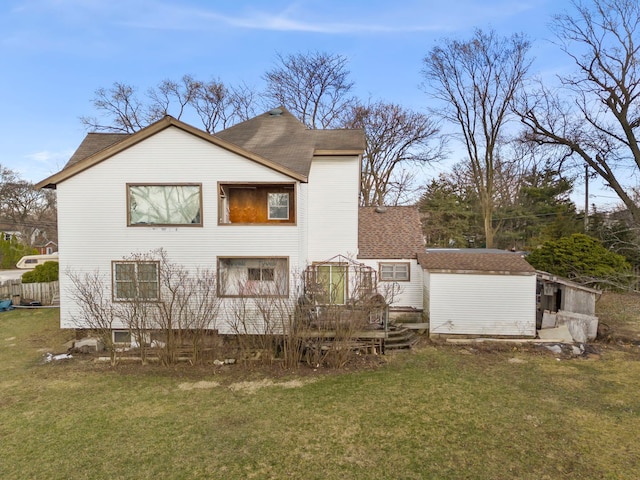 rear view of house featuring a wooden deck, an outbuilding, and a yard