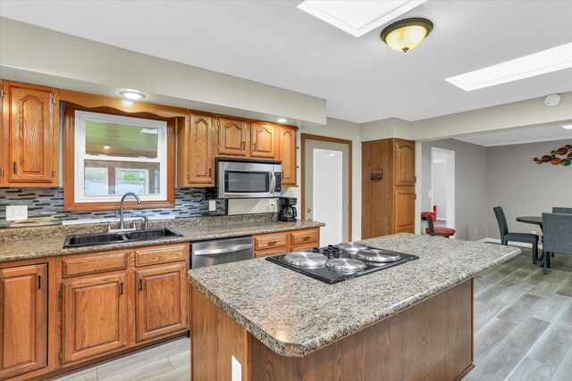 3104 Park Haven Blvd, Danville, IL 61832 - kitchen featuring stainless steel appliances, a sink, backsplash, light wood-type flooring, and a center island
