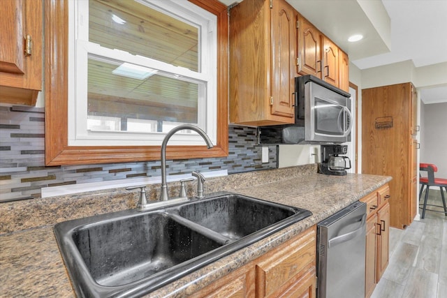 3104 Park Haven Blvd, Danville, IL 61832 - kitchen featuring appliances with stainless steel finishes, a sink, tasteful backsplash, light wood-type flooring, and brown cabinetry