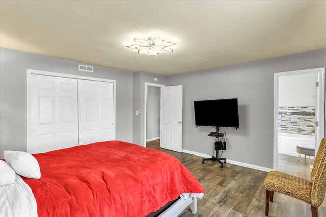 3104 Park Haven Blvd, Danville, IL 61832 - bedroom with dark wood-style flooring, baseboards, a closet, ensuite bath, and a textured ceiling