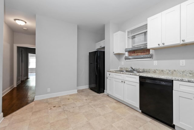 kitchen with white cabinetry, light stone countertops, black appliances, and a sink