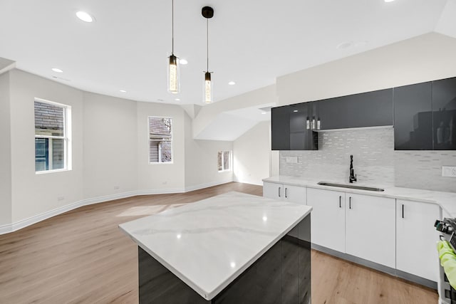 kitchen featuring decorative backsplash, a sink, and light wood-type flooring
