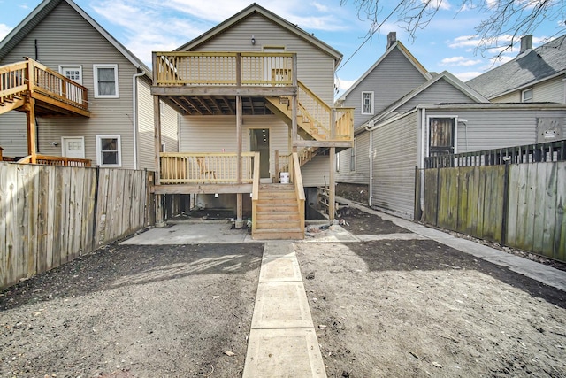 rear view of property with stairs, a fenced backyard, and a deck