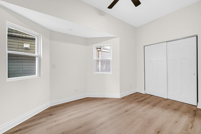 unfurnished bedroom with baseboards, a ceiling fan, light wood finished floors, and a closet