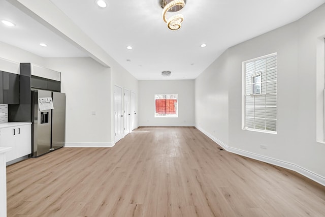 unfurnished living room featuring baseboards, recessed lighting, and light wood-type flooring