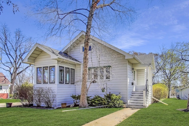 bungalow featuring a shingled roof and a front yard