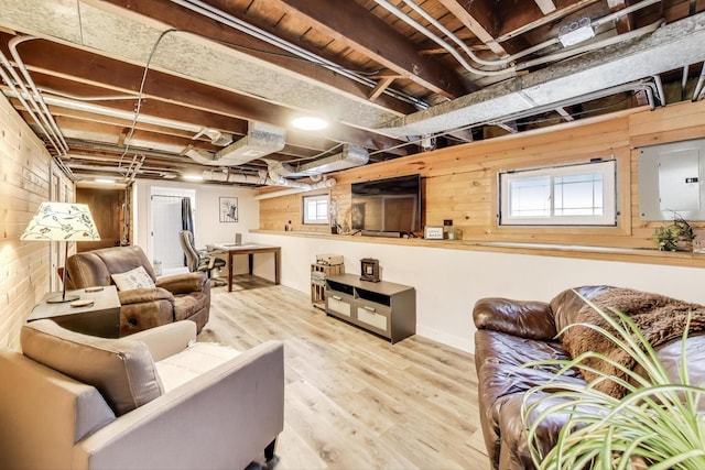 living room with wood finished floors, wooden walls, and electric panel