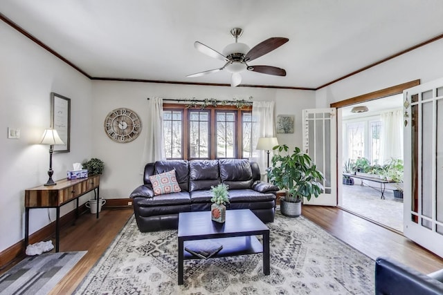 living room featuring crown molding, baseboards, a ceiling fan, and wood finished floors