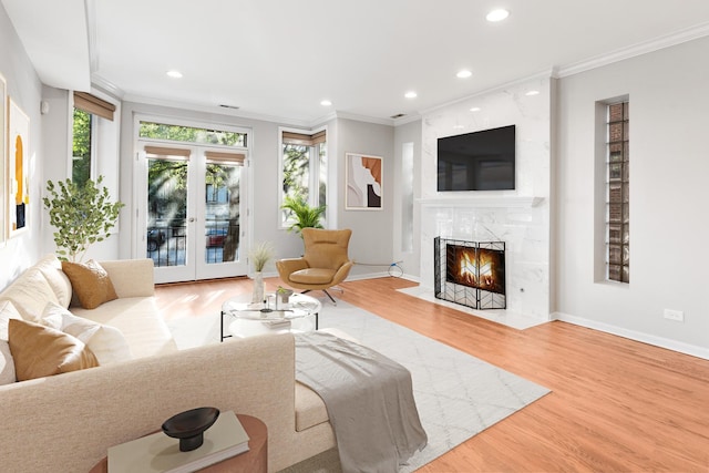 living room featuring crown molding, recessed lighting, wood finished floors, and a fireplace
