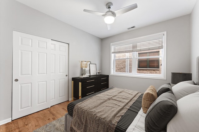 bedroom with visible vents, a closet, baseboards, light wood-type flooring, and a ceiling fan