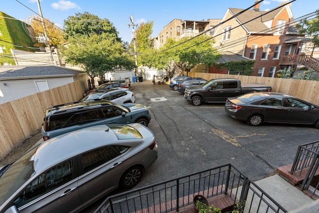 uncovered parking lot with fence and a residential view