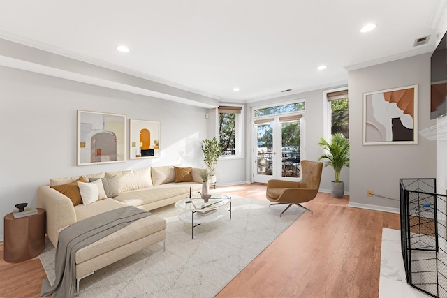 living room with recessed lighting, visible vents, ornamental molding, and light wood-style flooring