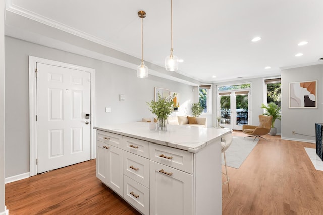 kitchen featuring recessed lighting, open floor plan, ornamental molding, and light wood-style floors