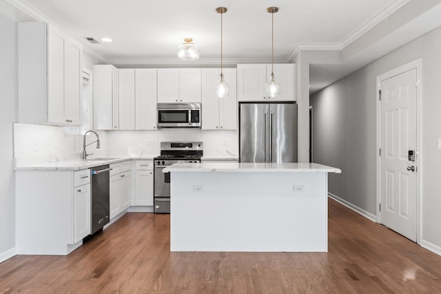 kitchen with crown molding, baseboards, a center island, a sink, and stainless steel appliances