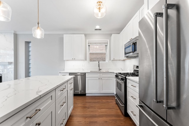 kitchen featuring crown molding, white cabinetry, appliances with stainless steel finishes, and tasteful backsplash