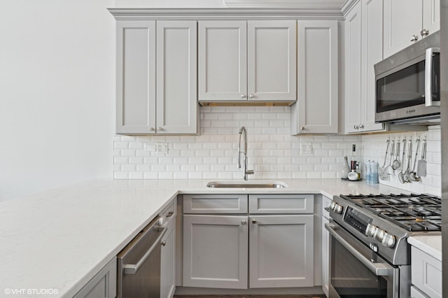 29 N Morgan St Unit Ph, Chicago, IL 60607 - kitchen with stainless steel appliances, a sink, backsplash, and gray cabinetry