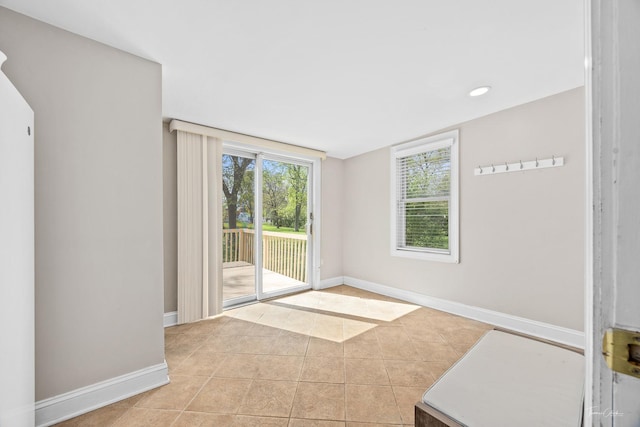 empty room featuring light tile patterned floors, baseboards, and recessed lighting