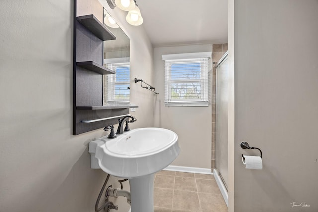 bathroom with a shower stall, baseboards, and tile patterned floors