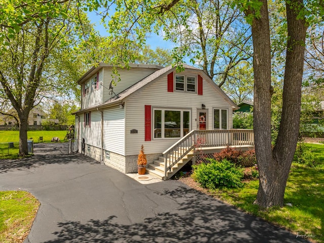 view of front facade with a deck and a front lawn