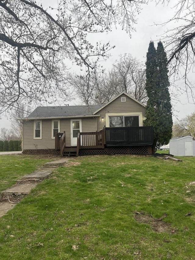 rear view of house featuring a yard, an outbuilding, a deck, and a storage shed