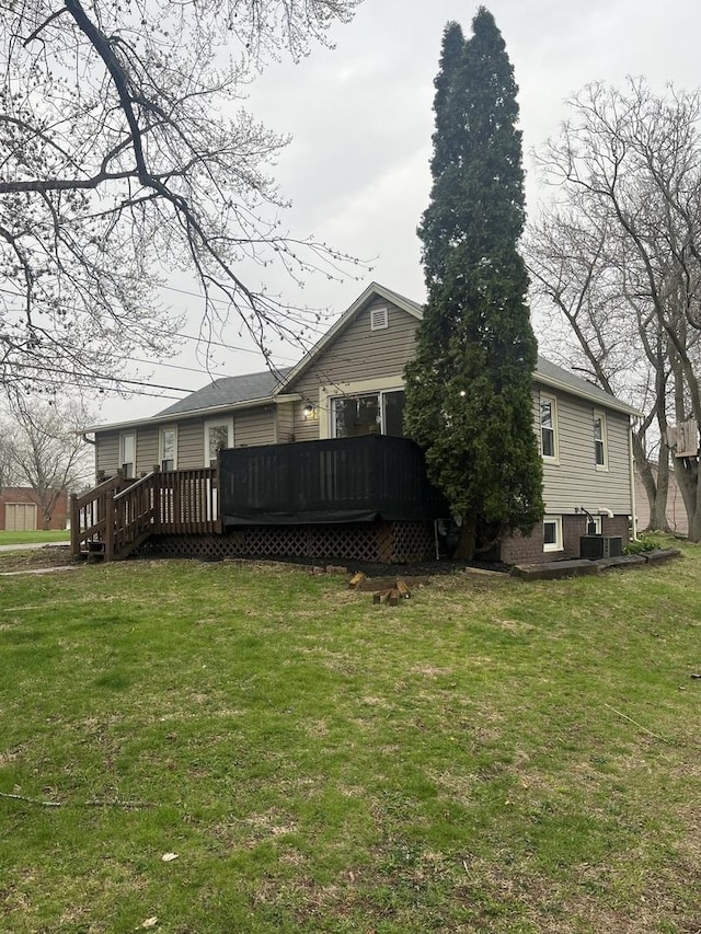 rear view of house featuring a yard and a deck