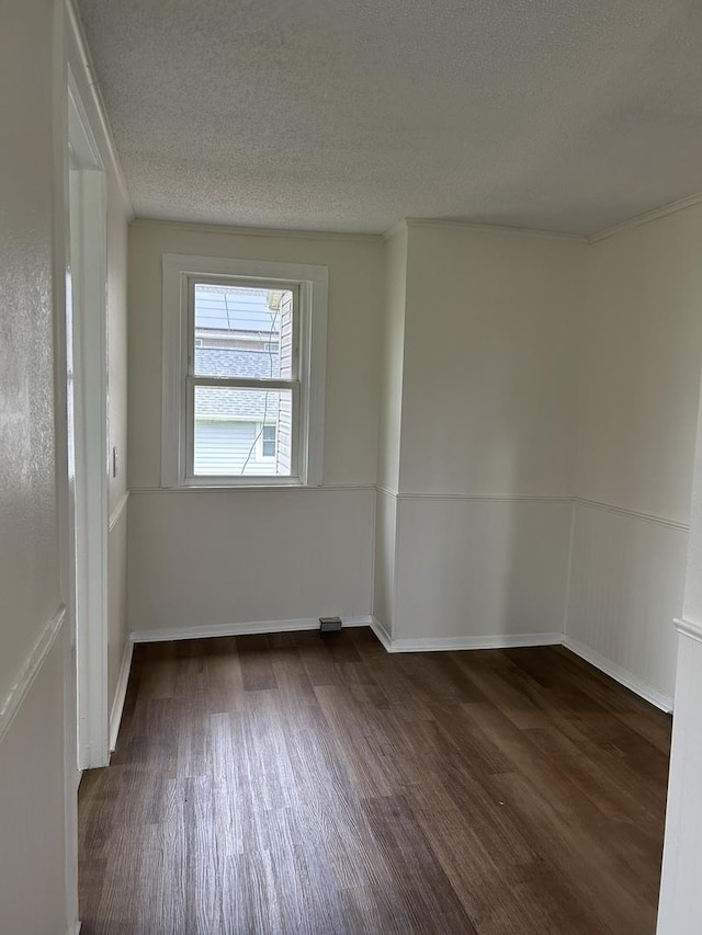 empty room with dark wood finished floors and a textured ceiling