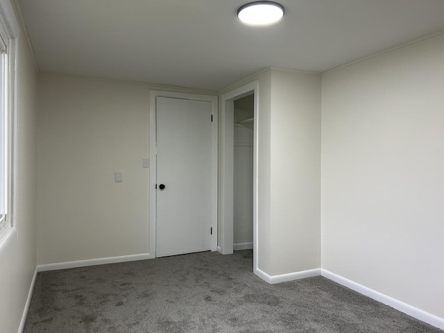 carpeted empty room featuring baseboards