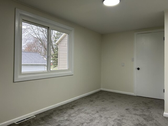 empty room with baseboards, carpet flooring, and visible vents