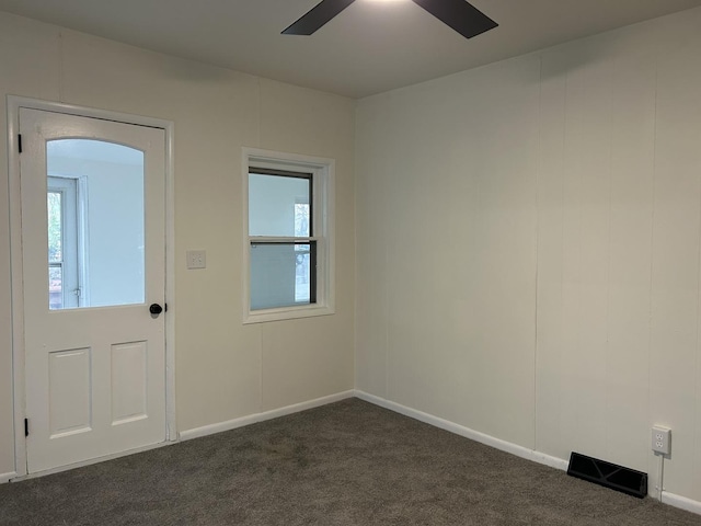 foyer with dark carpet, a wealth of natural light, baseboards, and ceiling fan