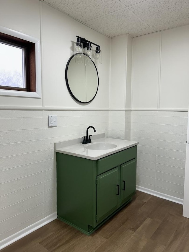 bathroom with vanity, wood finished floors, and a paneled ceiling