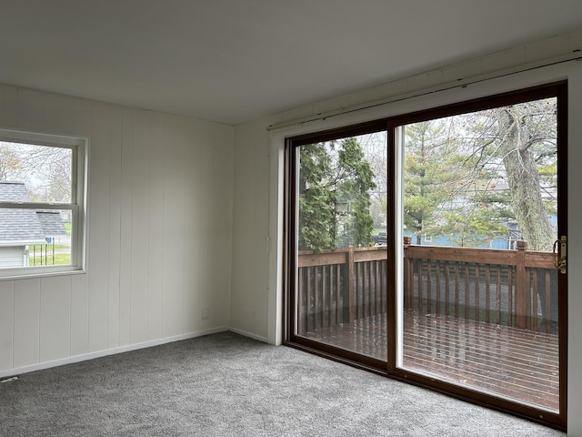 carpeted empty room featuring baseboards