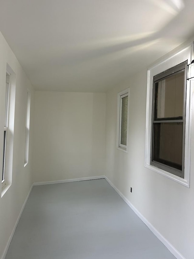 spare room with concrete flooring and baseboards