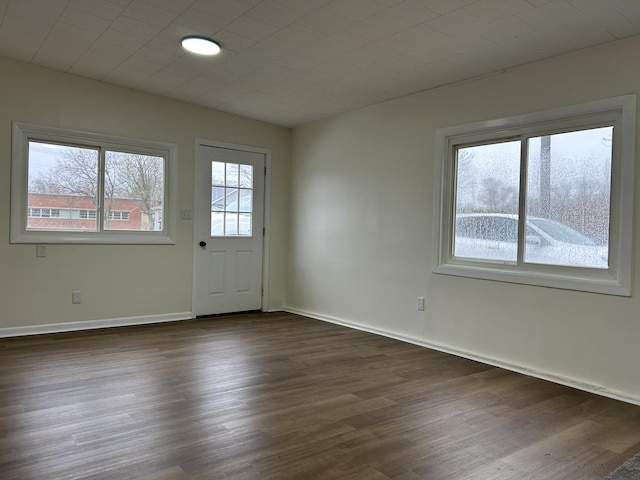 interior space with baseboards and dark wood-style flooring