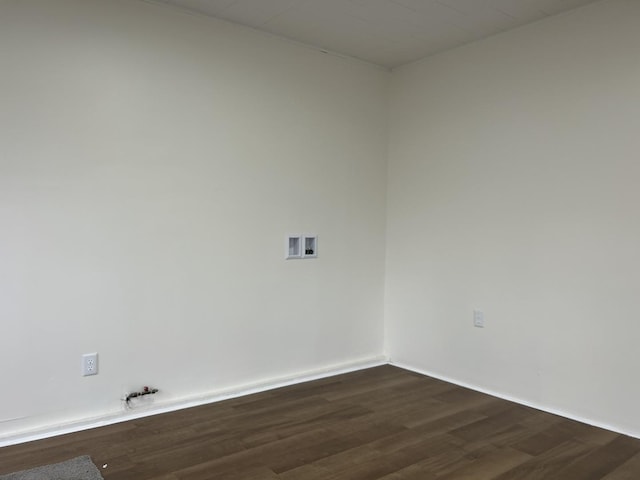 unfurnished room featuring baseboards and dark wood-style flooring