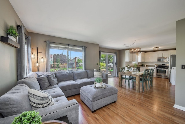 living room featuring light wood-type flooring and a chandelier
