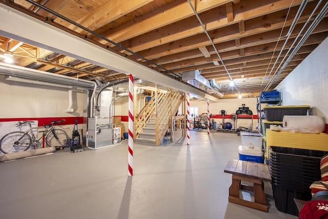 unfinished below grade area featuring stairway and heating unit