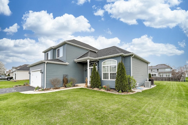 traditional-style house featuring roof with shingles, central AC unit, a front yard, and aphalt driveway