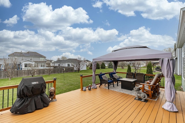 wooden deck featuring a gazebo, a lawn, outdoor lounge area, grilling area, and fence