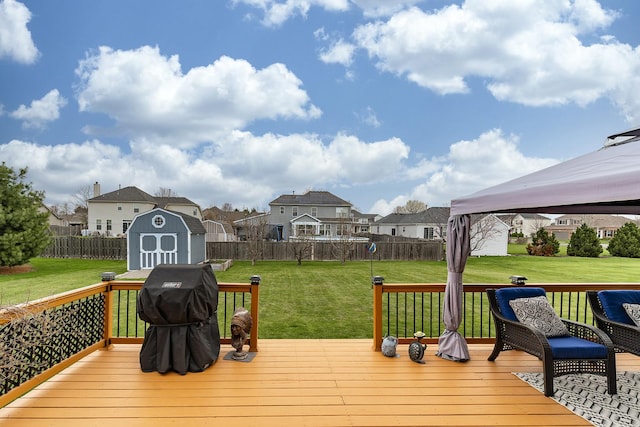 wooden terrace with a residential view, a lawn, a shed, and fence