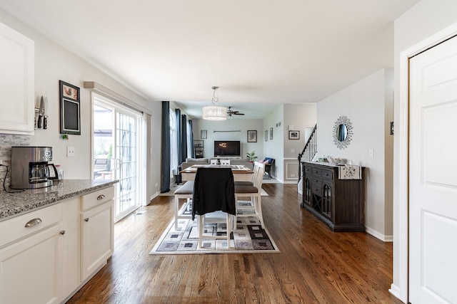 dining room featuring stairway, baseboards, and wood finished floors